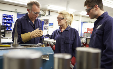 Mand instruerer kollega på fabrik